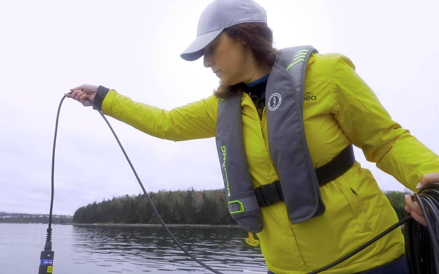 Women lowering an environmental sensor into the water