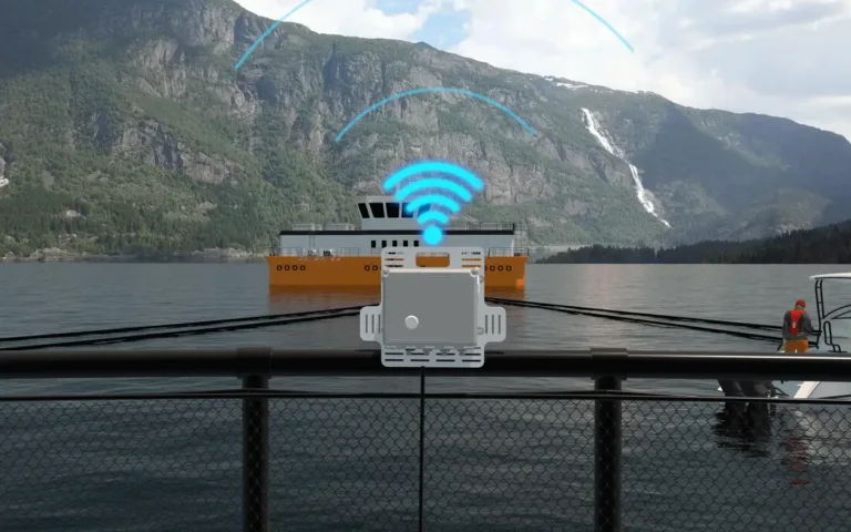 A wireless router device on a dock extends WiFi signal to a ferry boat on a fjord surrounded by mountains.